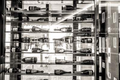 Mur avec des bouteilles posées sur des étagères au bar de l'Hôtel de la Paix, hôtel 4 étoiles à Reims